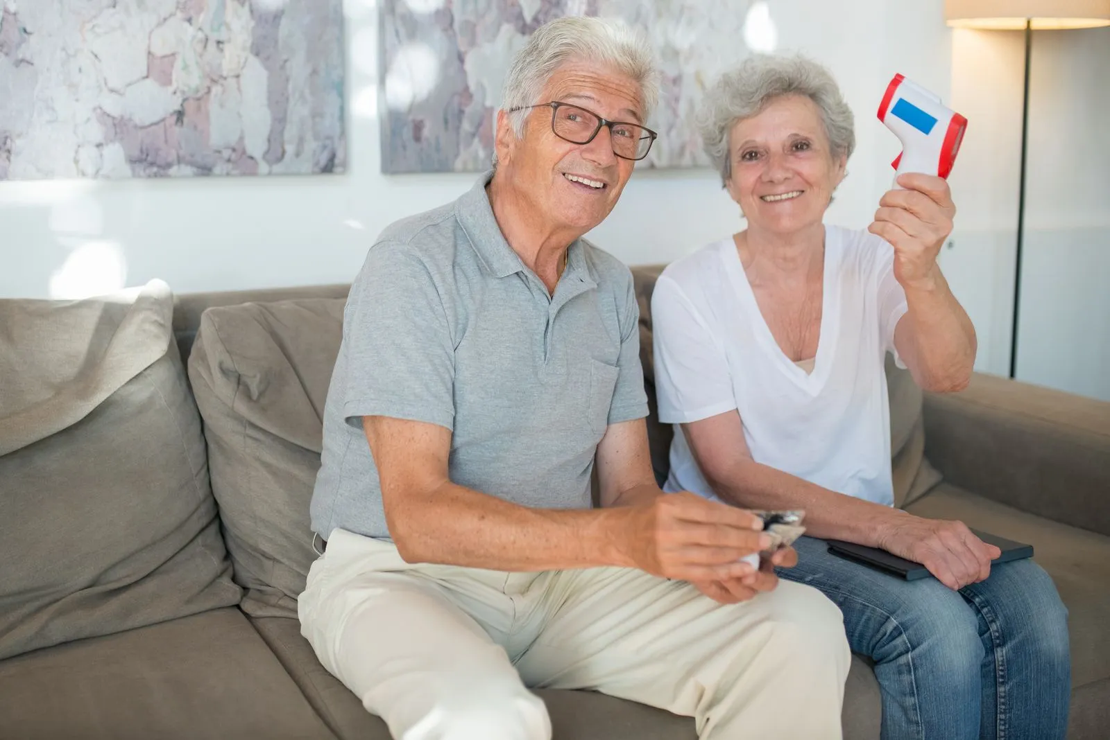 A cheerful elderly couple relaxing on their sofa
