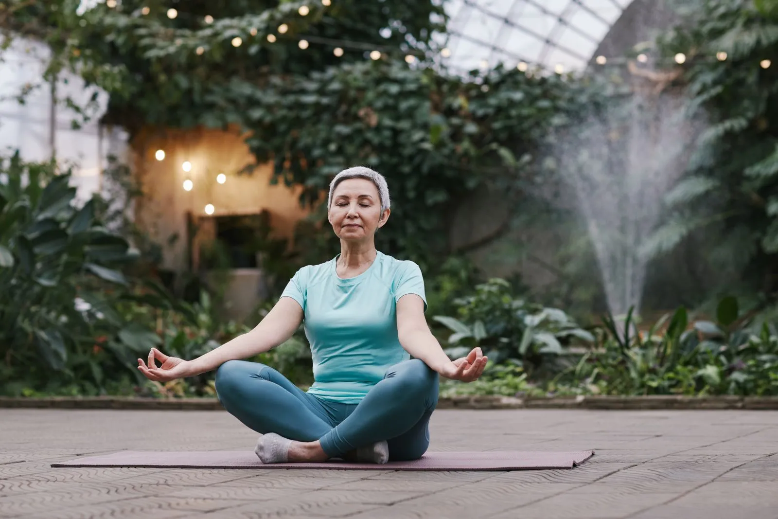 A woman practicing gentle exercise in a garden room